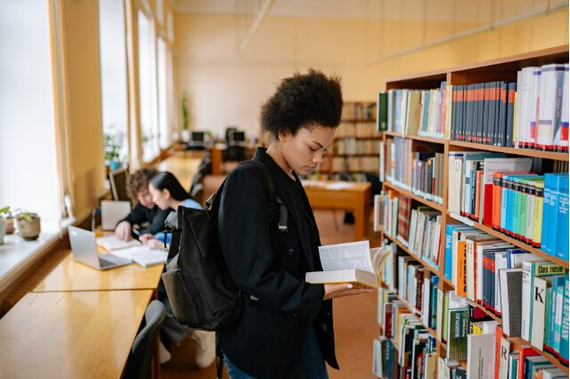 Mulher lendo livro na biblioteca