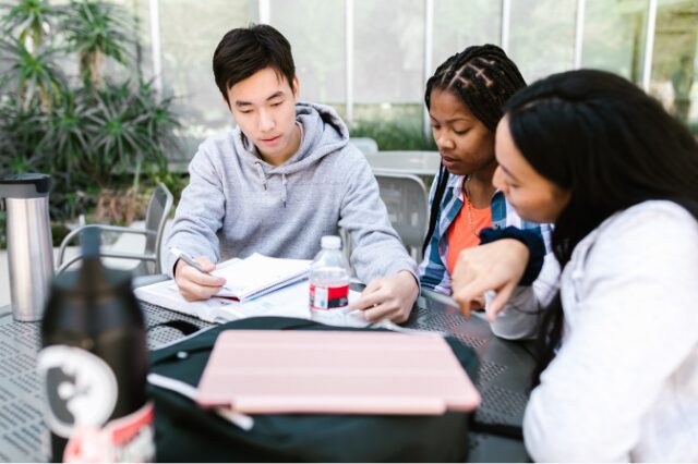 Pessoas sobre uma mesa trabalhando em um novo projeto