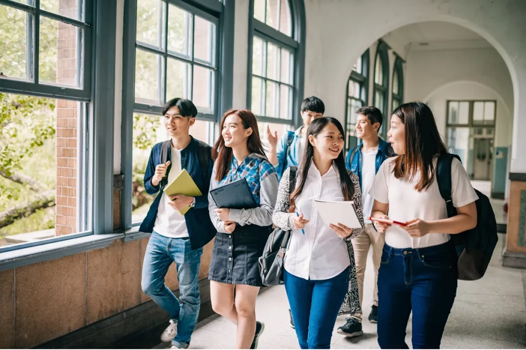 Grupo de estudantes sorridentes em corredor de universidade
